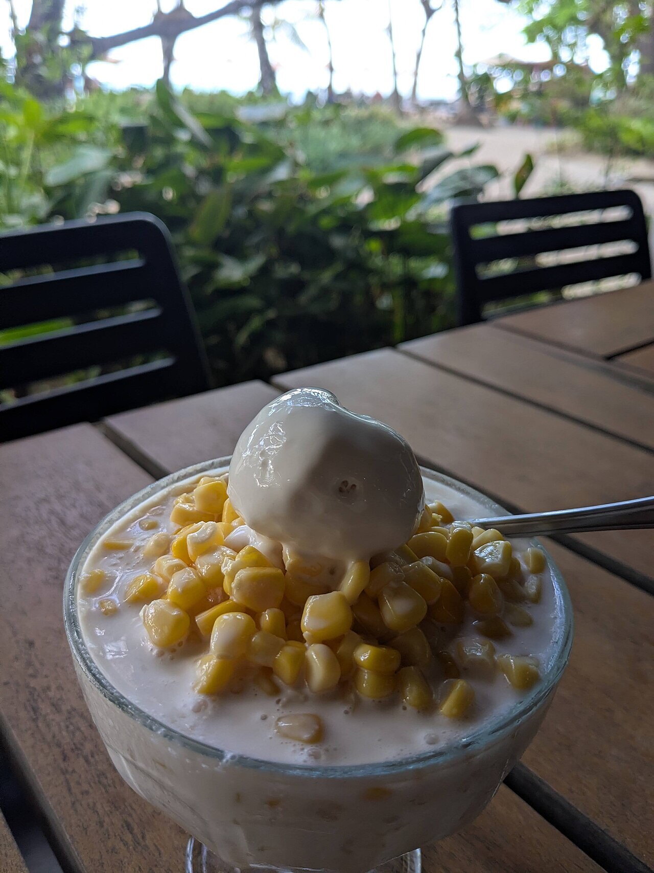 Mais con Hielo: Filipino Sweet Corn Shaved Ice - A glass of Mais con Yelo, a refreshing Filipino dessert made of corn kernels, milk, and shaved ice, topped with ice c.