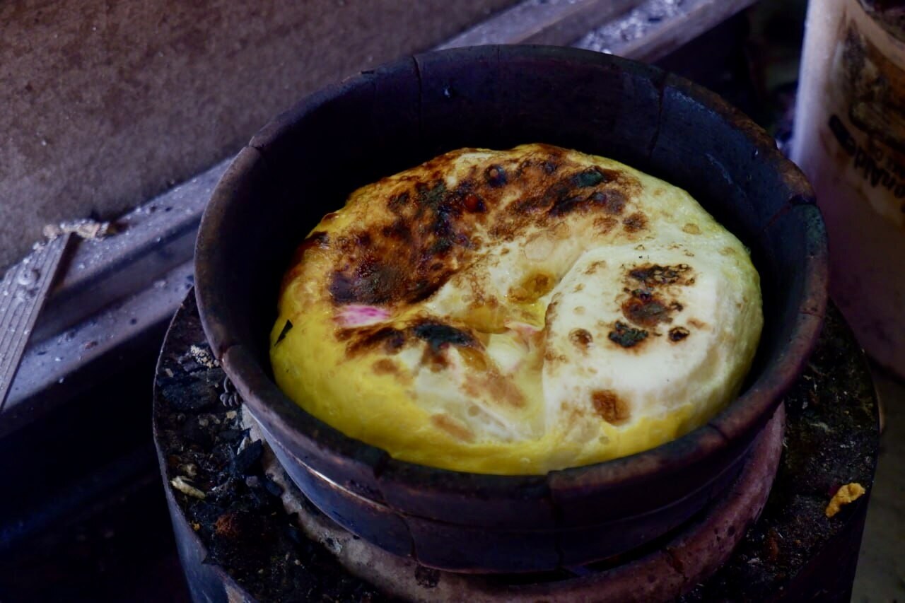 Bibingka: Filipino Coconut Rice Cake - Bibingka cooking over charcoal.
