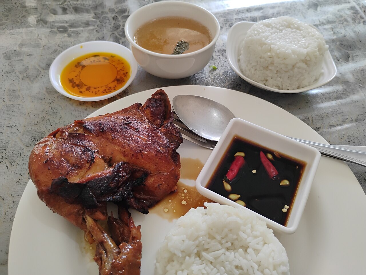 Chicken Inasal: Filipino Grilled Chicken with Annatto Oil - Chicken inasal meal with condiments.