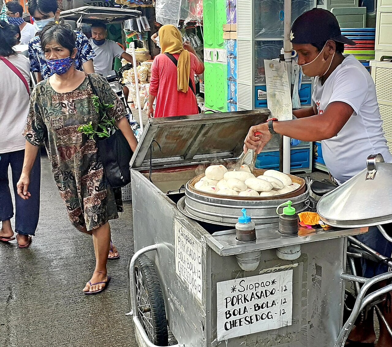 Siopao Asado: Steamed Filipino Buns with Sweet Pork Filling - A street vendor selling pork asado and bola-bola siopao varieties and cheesedog on a tricycle food cart near Powerlin.