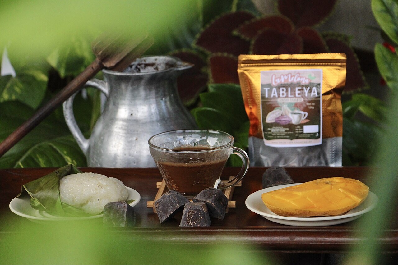 Puto Maya with Sikwate: Cebuano Sticky Rice and Hot Chocolate - Puto Maya and Sikwate paired with ripe mango, offer a delightful blend of traditional Filipino flavors with a tropica.