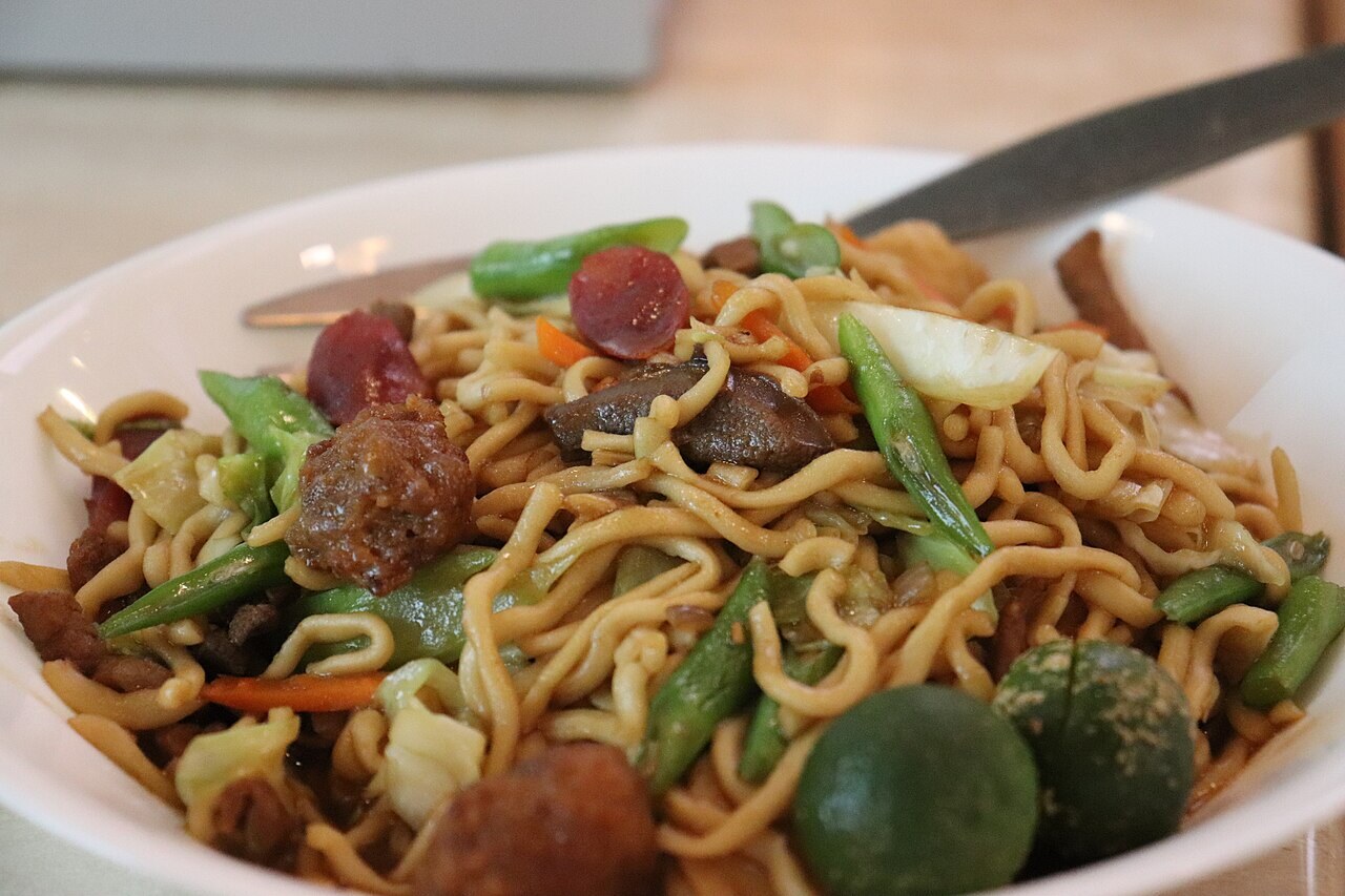 Pancit Guide: Bihon, Canton, Palabok, Sotanghon, and More - Pancit canton guisado served with calamansi.