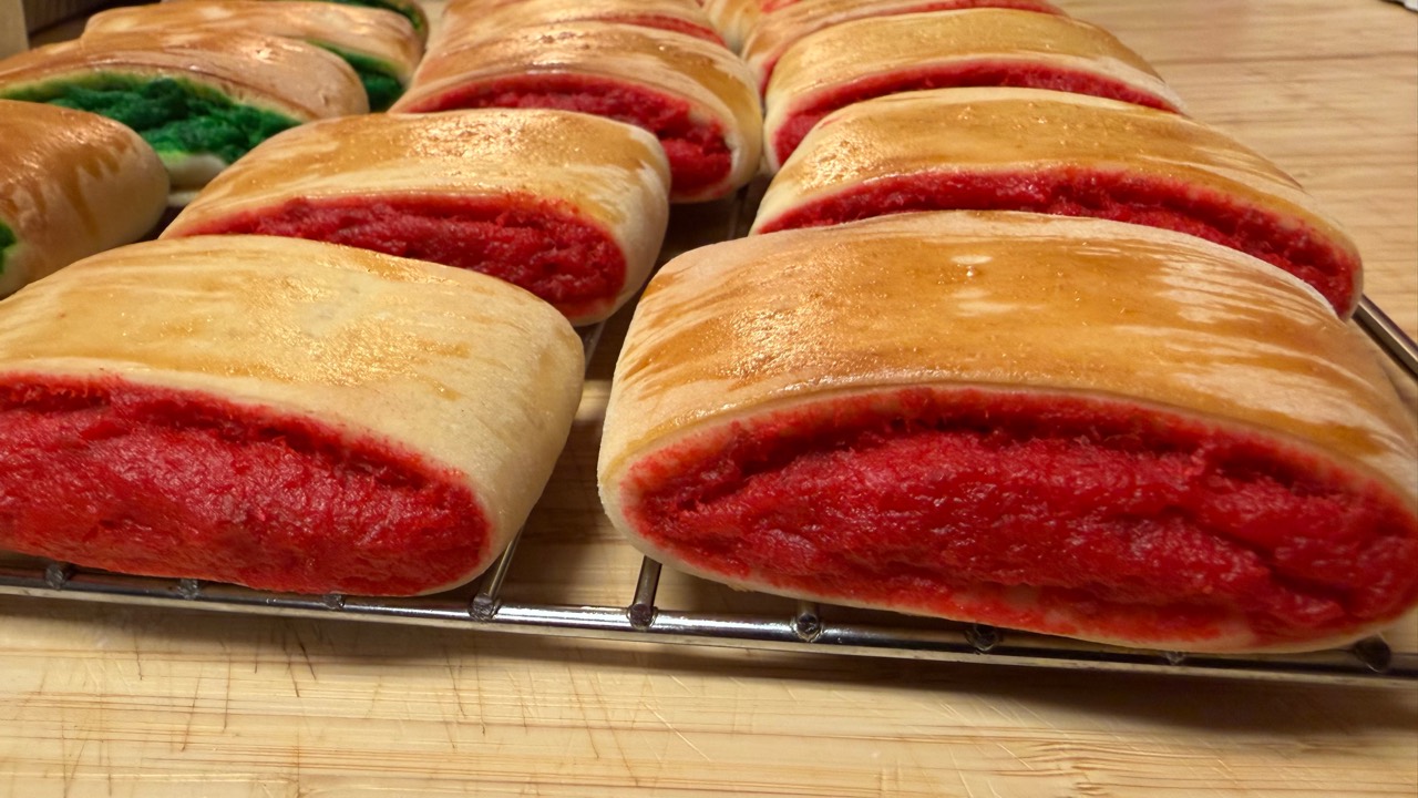 Close-up of Burikat bread with red pudding filling on a cooling rack