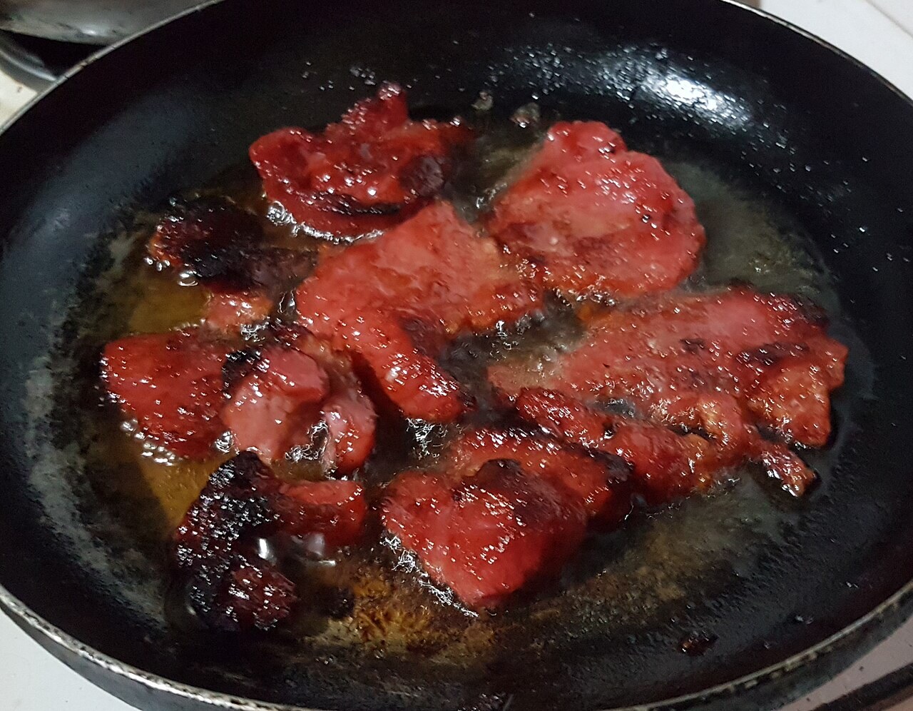 Tocino Breakfast Sandwich with Garlic Mayo - Philippine tocino cooking in a pan.