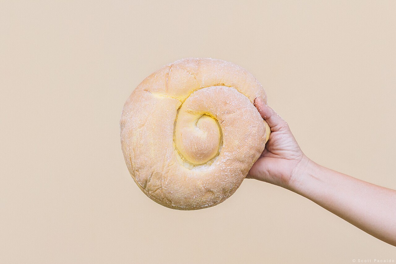 Ensaymada: Filipino Brioche with Butter, Sugar, and Cheese - Ensaymada served on a plate.