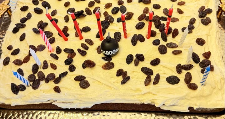 Maple cream cheese frosting spread over persimmon cake with raisins