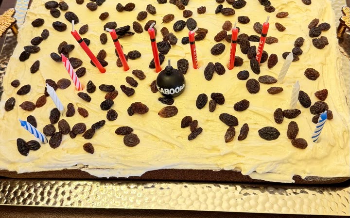 Persimmon cake with maple cream cheese frosting, raisins, and birthday candles